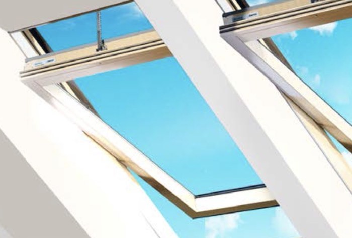 DACHGEWERK Elektro-Schwingfenster DSFH Holz Detailansicht zweier DACHGEWERK Elektro-Schwingfenster DSFH Holz im Einbau als Zwilling, von innen gesehen, halb geöffnet; im Hintergrund strahlend blauer Himmel